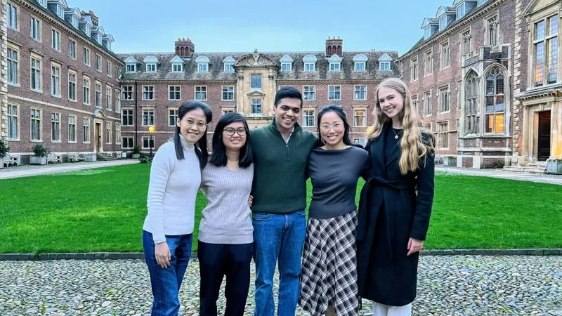 Group photograph of five people in a college courtyard, from the Emmanuel College announcement of the Cambridge Health Futures Conference